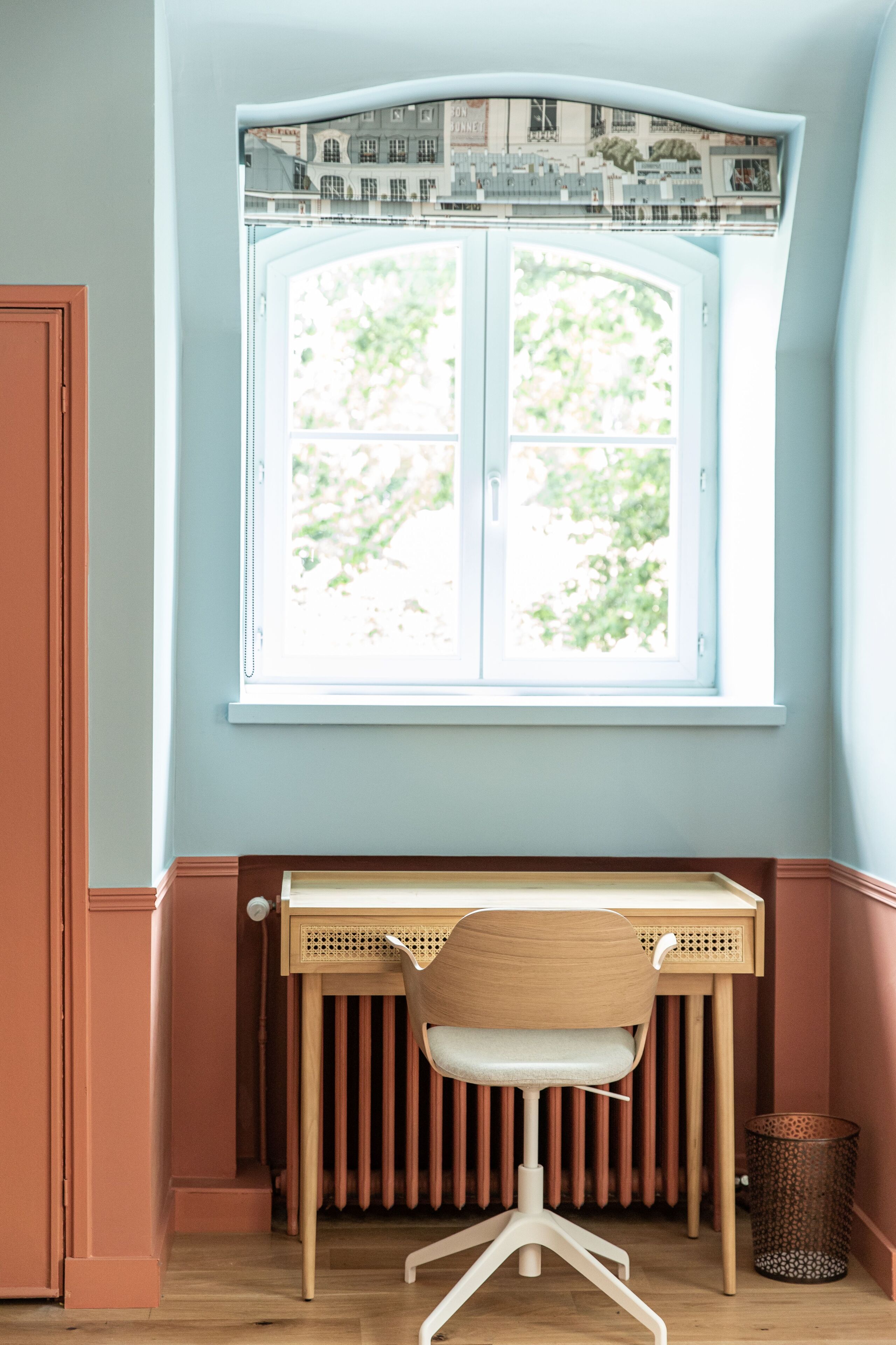 A study with a window, radiator, and a chair.