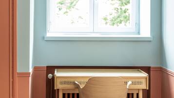 A study with a window, radiator, and a chair.