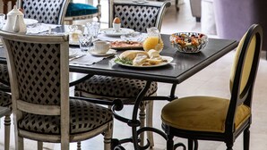 A dining area with a chandelier, a table set for breakfast, and a view of the living room. - La Castagnère de Bergory (Wervicq-Sud)
