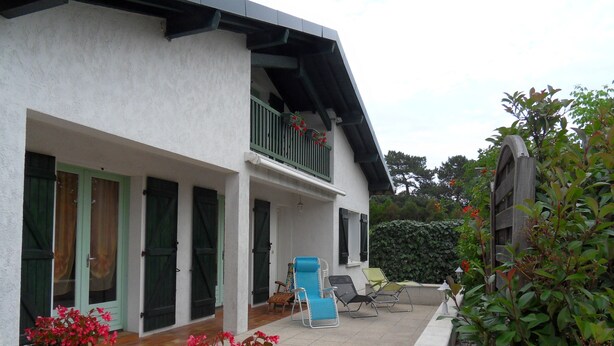 A two-story house with a balcony, a covered porch, and outdoor seating. - Quiet house between forest and ocean 2 weeks minimum rental (Seignosse)