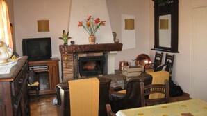 A cozy living room with a fireplace, a television, and comfortable seating. - Quiet house between forest and ocean 2 weeks minimum rental (Seignosse)