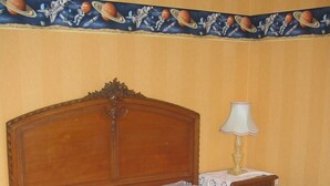 A bedroom with a wooden bed, a nightstand with a lamp, and a wall with a space-themed border. - Quiet house between forest and ocean 2 weeks minimum rental (Seignosse)