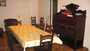A dining room with a long table, chairs, a wooden cabinet, and a chandelier. - Quiet house between forest and ocean 2 weeks minimum rental (Seignosse)