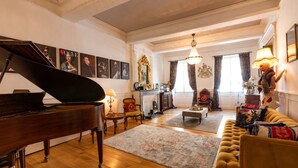 Un amplio salón con un piano de cola, un sofá, una mesa de centro y una chimenea.