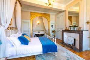 Um quarto luxuoso com cama de dossel, um piano preto, lareira e decoração requintada.