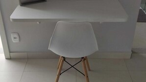 Una habitación moderna y minimalista con un escritorio y una silla blancos.