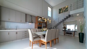 Een moderne keuken met een eethoek, met een trap en uitzicht op het buitengebied.