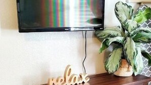 Een houten entertainmentkast met een flatscreen televisie erboven.