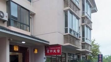 A multi-story building with a red sign indicating a guesthouse.
