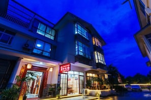 A multi-story building with a storefront at the ground level. - Mingxuan Inn (Wuyishan)