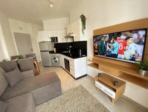 Apartamento, varias camas | Sala de estar | Televisión de 30 pulgadas con canales por cable