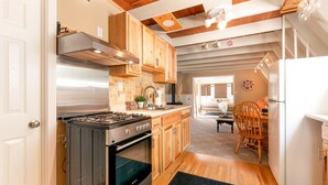 Une cuisine avec des armoires en bois, une cuisinière en acier inoxydable et un réfrigérateur.
