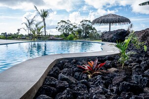 Una piscina al aire libre, sombrillas, tumbonas