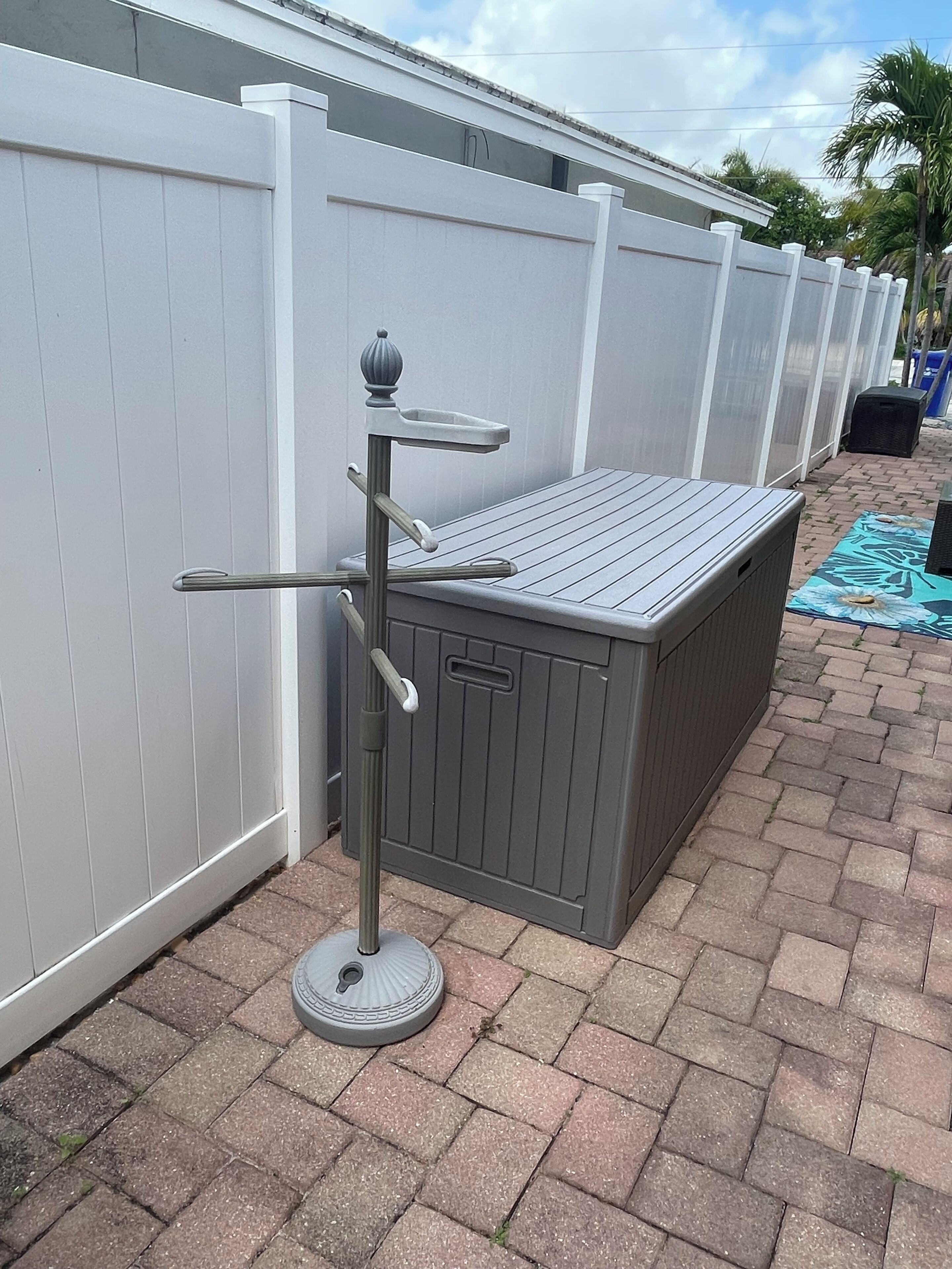 Eine Terrasse mit integriertem Grill, einem Metall-Outdoortisch und einer überdachten Sitzgruppe.