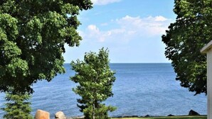A view of a lake with trees and a building on the right. - Newly renovated lakefront townhome with incredible views of Mille Lacs Lake (Onamia)