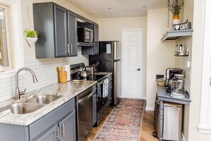 Fully equipped kitchen with a coffee machine, refrigerator, and microwave.
