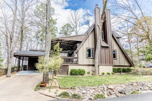Stunning two-story home with a prominent chimney, covered porch, and beautifully manicured yard.