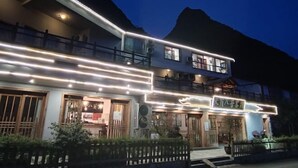 A two-story building with a balcony and a sign in a foreign language. - Tianla Bayin Inn (Xingyi)