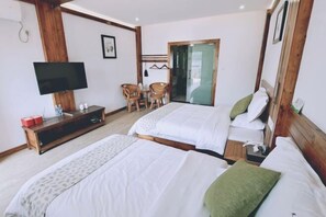 A hotel room with two beds, a TV, a wooden cabinet, a chair, and a door leading to a balcony. - Tianla Bayin Inn (Xingyi)