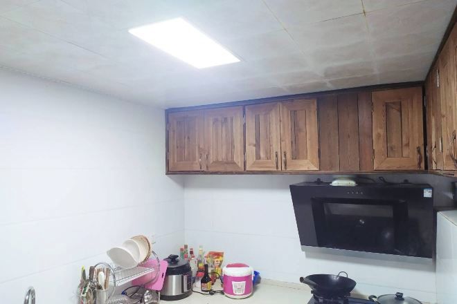 A kitchen with wooden cabinets, a microwave, and various kitchen items on the counter.