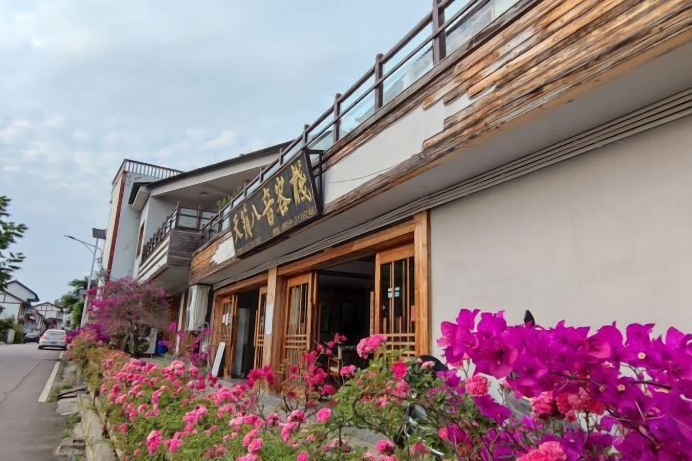 A building with a signboard, wooden doors, and a balcony.