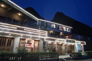 Un bâtiment à deux étages, doté d’une enseigne lumineuse et d’un balcon.