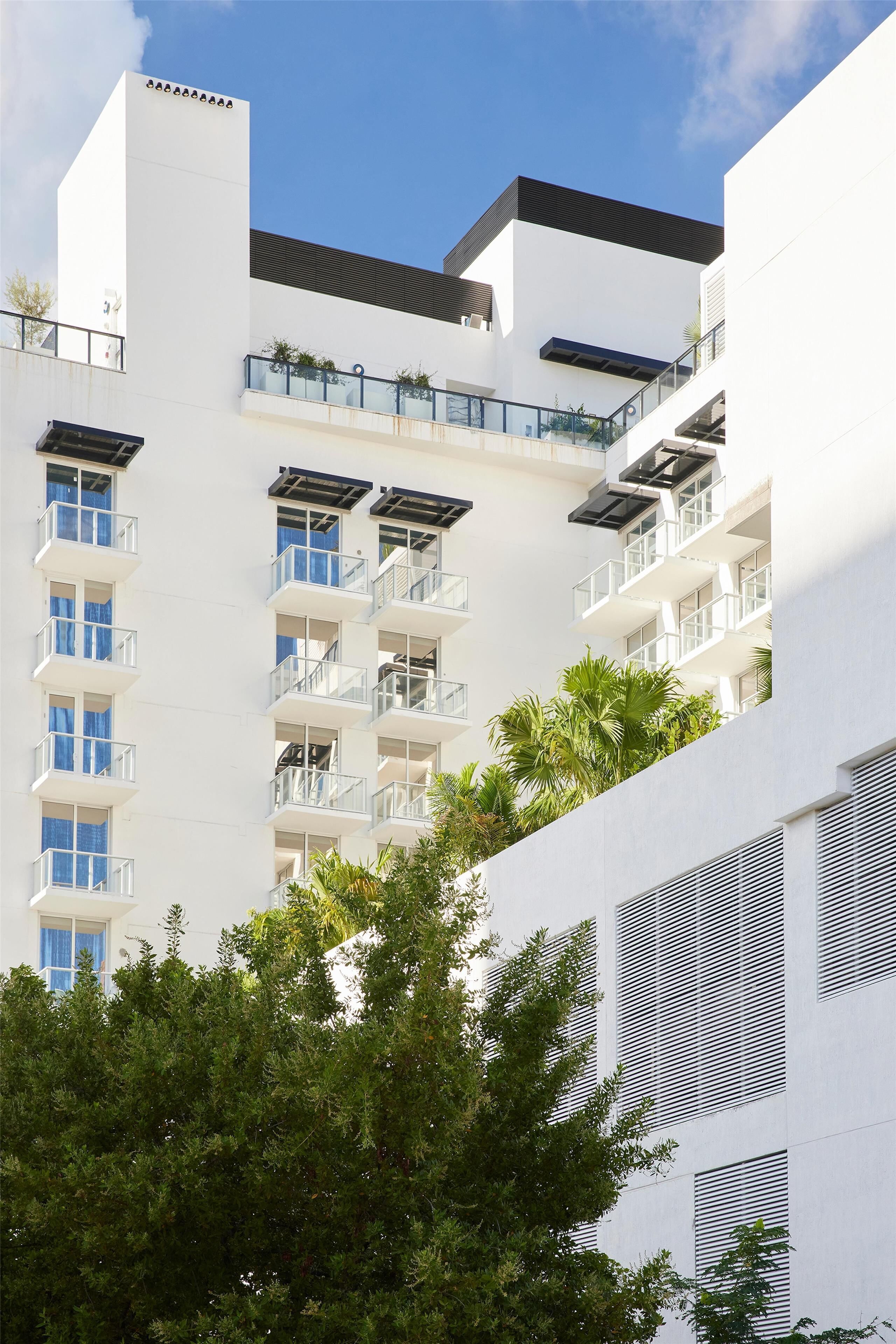 A modern multi-story building with balconies and large windows.