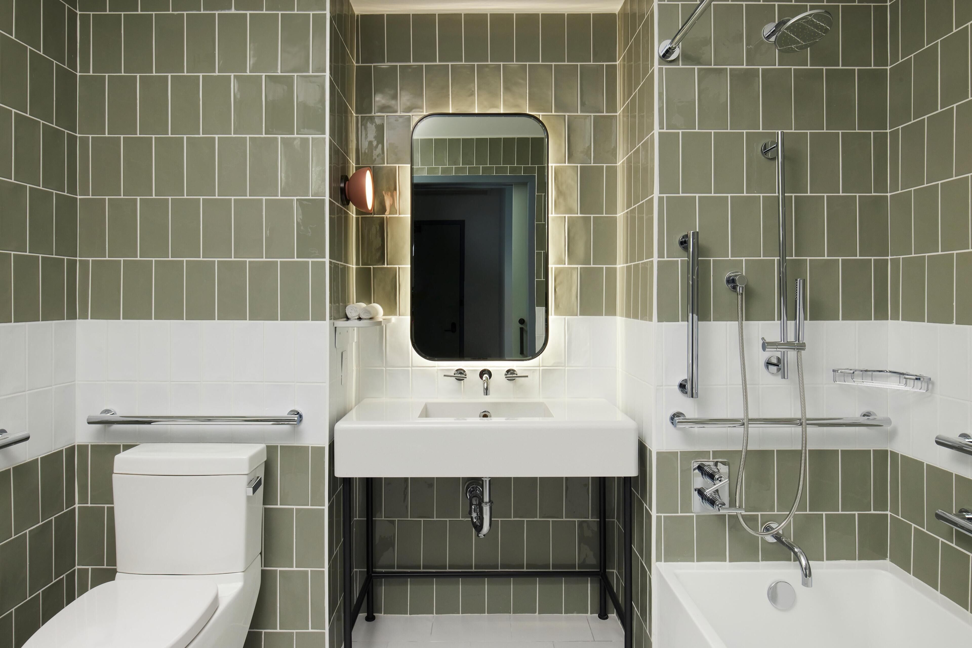 A modern bathroom with a white sink, a toilet, and a shower area.
