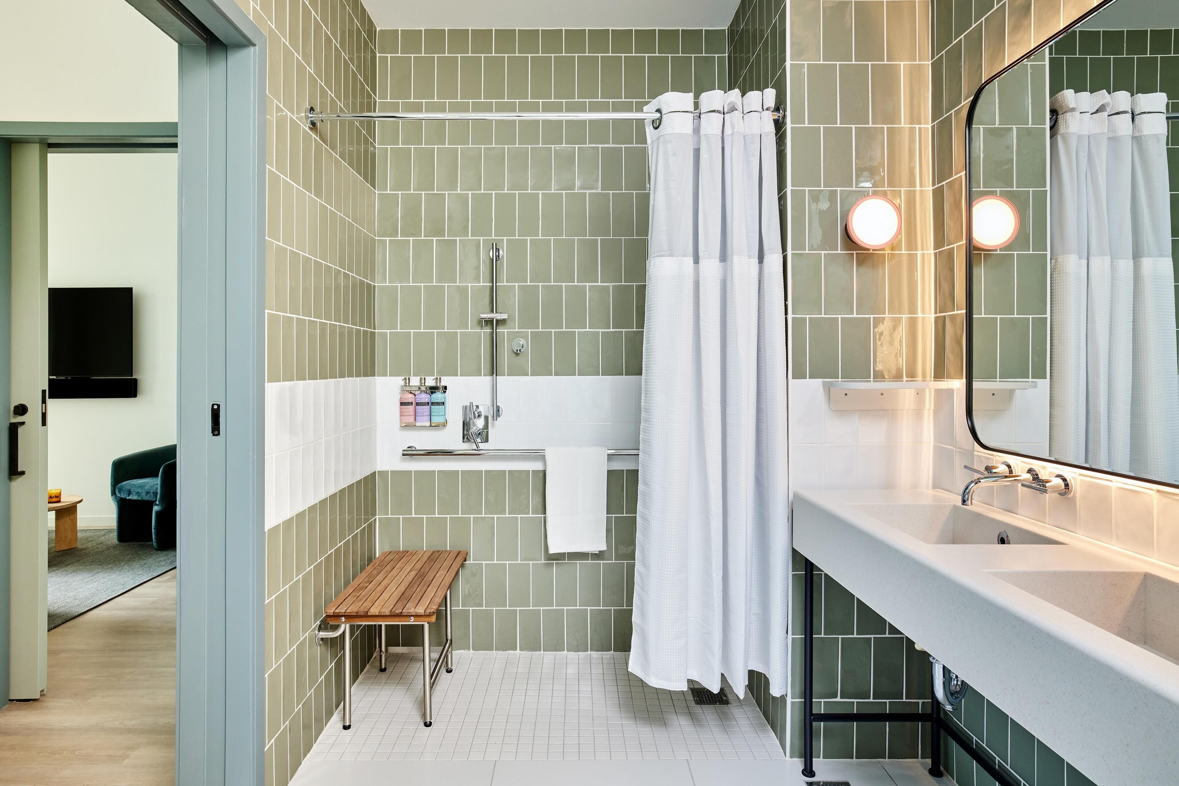 A modern bathroom with a shower, a vanity, and a bench.