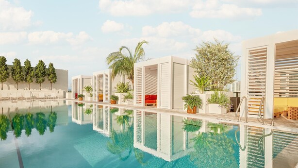 A modern pool area with clear water, lounge chairs, and potted plants. - Arlo Wynwood Miami (Miami)