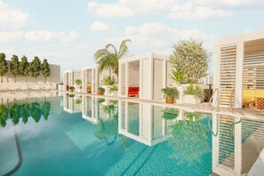 A modern pool area with clear water, lounge chairs, and potted plants. - Arlo Wynwood Miami (Miami)