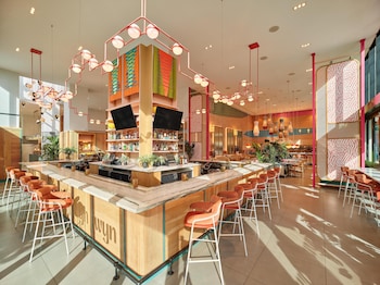 A modern restaurant with round tables, booths, and hanging pendant lights. at Arlo Wynwood Miami