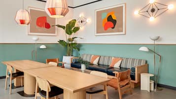 Un salon moderne avec une table à manger en bois, un canapé à rayures et deux lampes suspendues.