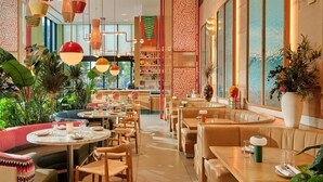 A modern restaurant with round tables, booths, and hanging pendant lights. - Arlo Wynwood Miami (Miami)