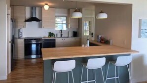 A modern kitchen with a central island, stainless steel appliances, and pendant lighting. - Upper Chesapeake Getaway - Newly Renovated (Perryville)