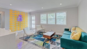 Un salon moderne avec un canapé, des fauteuils, une table basse et un tapis à motifs.