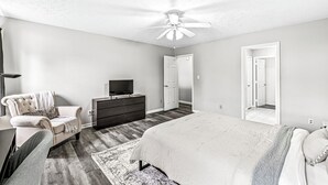 A bedroom with a bed, a dresser, a chair, a ceiling fan, and a TV. - 3-min from downtown Fishers (Fishers)
