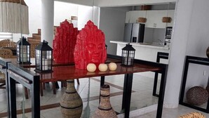 A modern dining area with a glass-top table, black metal frame, and woven baskets. - Confortable y amplio estudio D9 (Cozumel)