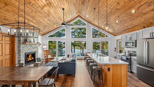 A spacious kitchen with a large island, a fireplace, and a view of the outdoors.