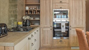 A kitchen with wooden cabinets, a built-in oven, and a coffee maker. - 2 bedroom accommodation in Landford, near New Forest (Landford, near New Forest)
