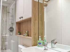 Une salle de bain avec douche, toilettes et lavabo.