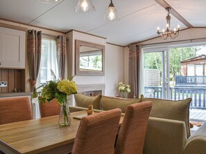 A cozy dining area with a wooden table, cushioned chairs, and a vase of flowers.