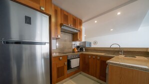 Una cucina moderna con elettrodomestici in acciaio inossidabile, mobili in legno, forno integrato e piano di lavoro in granito.