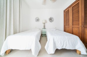 A room with two beds, a wooden wardrobe, and two wall decorations. - Wayak 301 - Center of Playa del Carmen (Playa del Carmen)