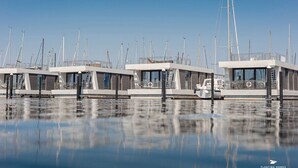 Maisons flottantes au design moderne, dotées de plusieurs niveaux et de grandes fenêtres.
