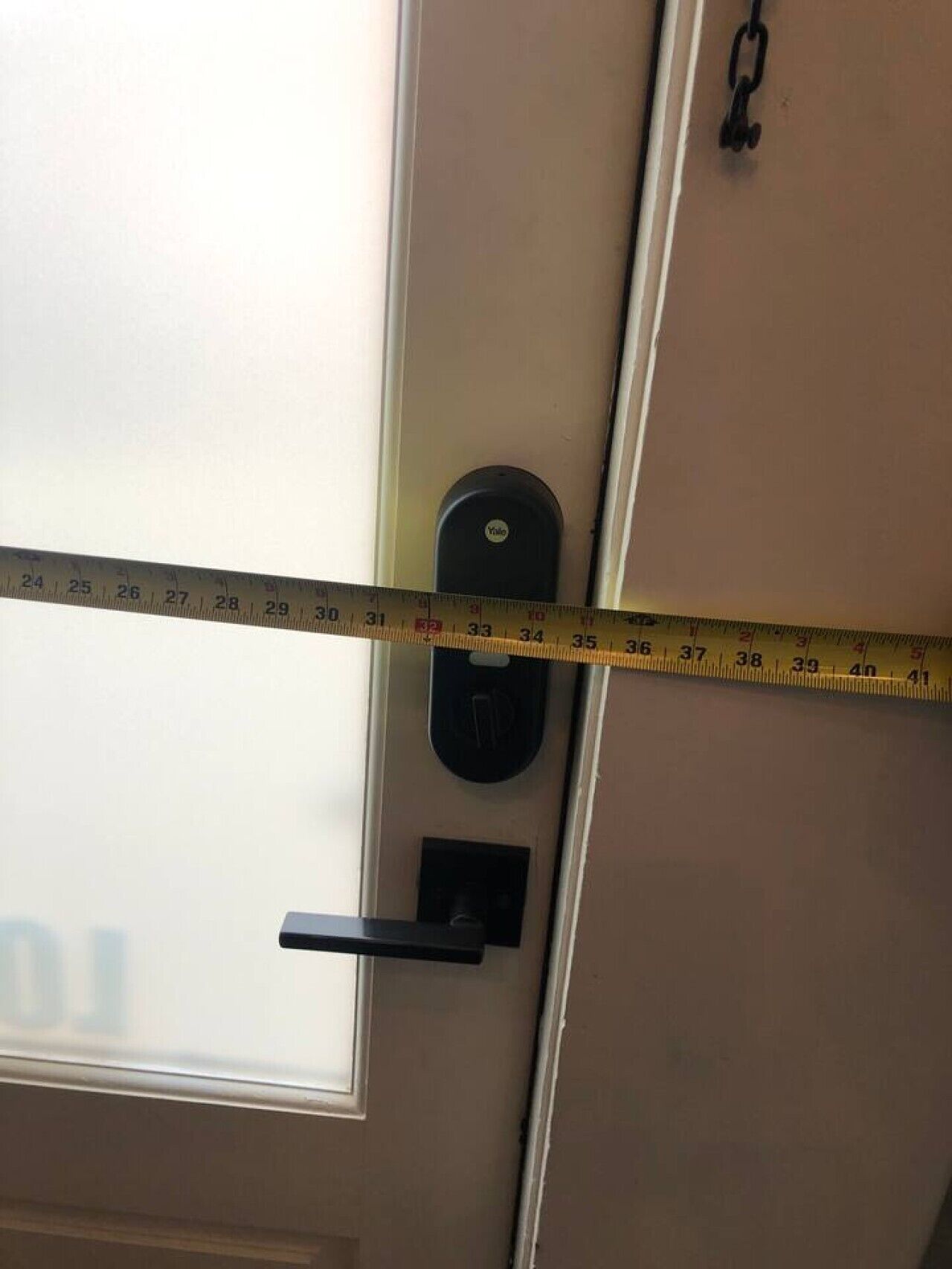 A measuring tape across a door, indicating the door's width.