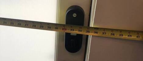 A measuring tape across a door, indicating the door's width.