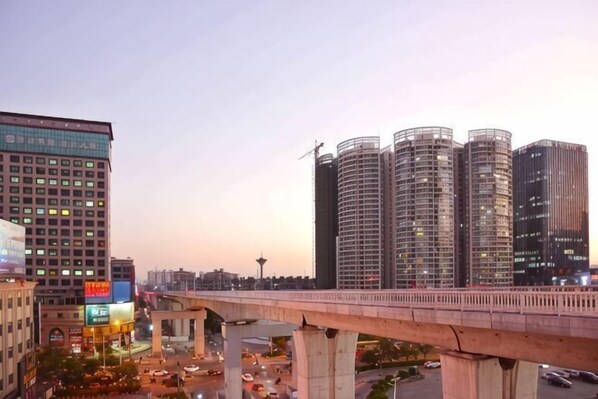 A cityscape with modern buildings, a bridge, and a busy street. - Kelly Hotel (Guangzhou Zengcheng Xintang South Station) (Guangzhou)