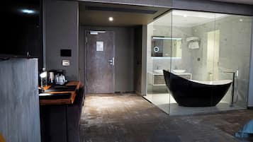 Un baño moderno con una bañera independiente, un box de ducha de vidrio y un tocador con un espejo grande.