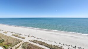 A beach with a clear sky, calm sea, and a sandy shore with a wooden walkway. - HS-1109 Oceanfront 1-Bedroom Condo in Myrtle Beach - Sleeps 6 (Myrtle Beach)